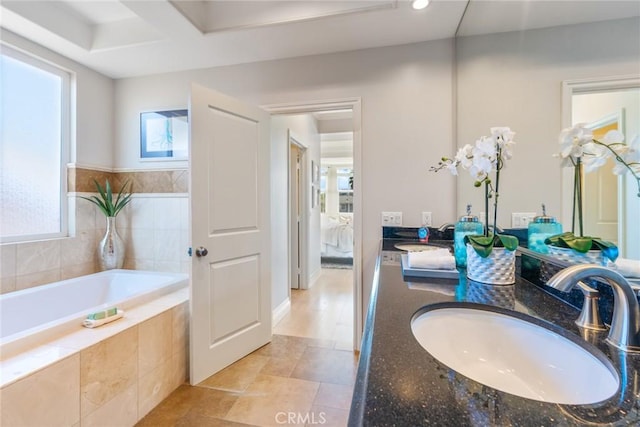 ensuite bathroom featuring a bath, ensuite bath, double vanity, and a sink