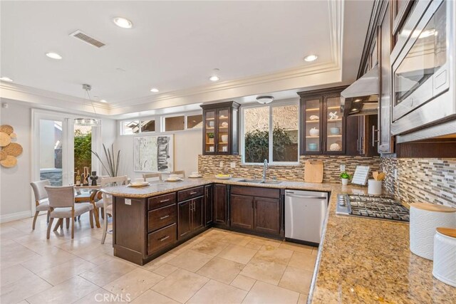 kitchen featuring visible vents, crown molding, stainless steel appliances, dark brown cabinets, and a sink