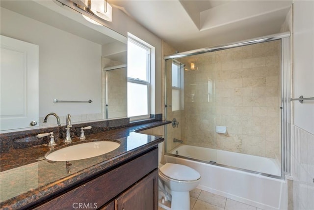 full bathroom featuring combined bath / shower with glass door, vanity, toilet, and tile patterned floors