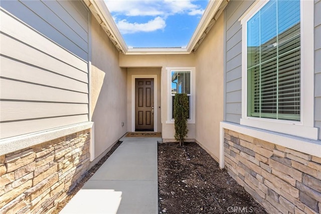 view of exterior entry with stucco siding