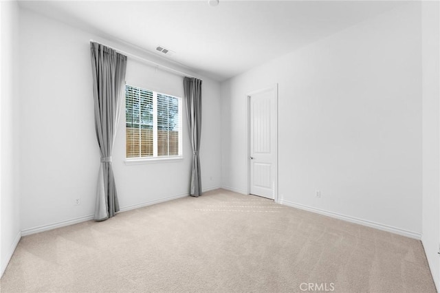 empty room with baseboards, visible vents, and carpet floors