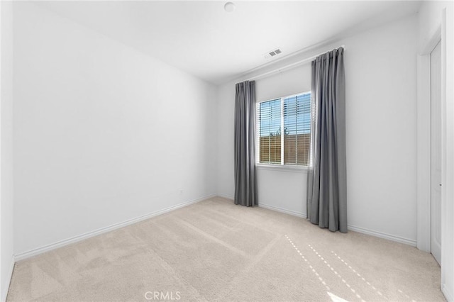 carpeted spare room featuring visible vents and baseboards