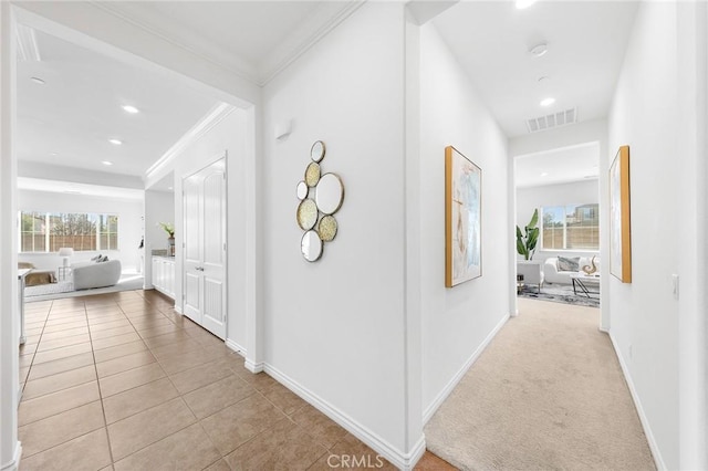 corridor featuring baseboards, visible vents, recessed lighting, crown molding, and tile patterned floors