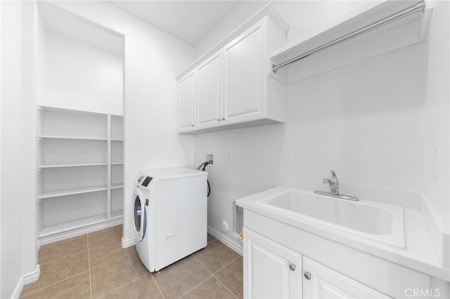 clothes washing area with washer / clothes dryer, cabinet space, light tile patterned flooring, and a sink