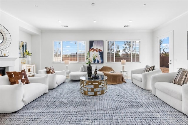 living room with a glass covered fireplace, visible vents, and ornamental molding