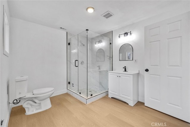 bathroom featuring a marble finish shower, visible vents, toilet, and wood finished floors