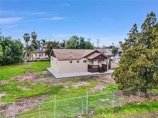 back of house featuring fence and a yard