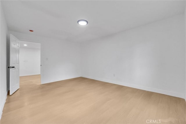 unfurnished room with baseboards and light wood-style floors