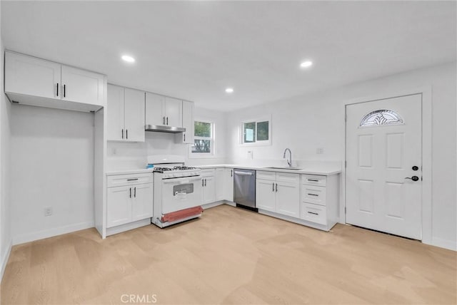 kitchen featuring dishwasher, gas range gas stove, a sink, and white cabinets