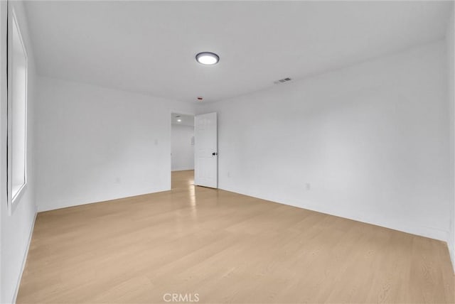 unfurnished room with light wood-style floors and visible vents