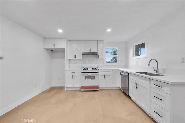 kitchen with stainless steel dishwasher, white cabinets, a sink, under cabinet range hood, and white gas range oven