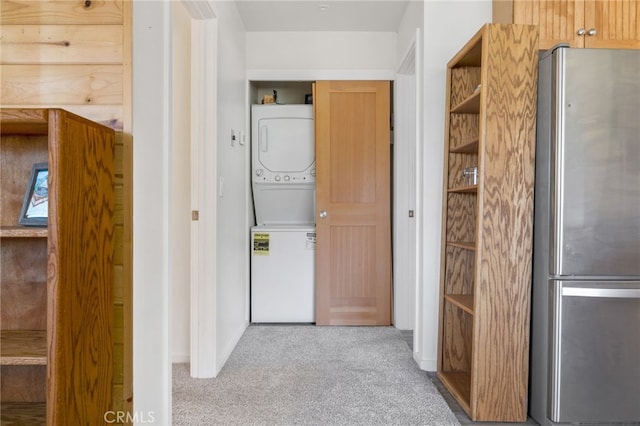 hall featuring stacked washer and dryer and carpet floors