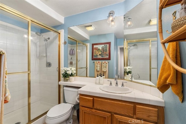 bathroom with vanity, toilet, and a shower stall