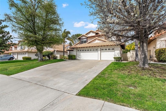 view of front facade with a front yard, an attached garage, stucco siding, concrete driveway, and a tiled roof