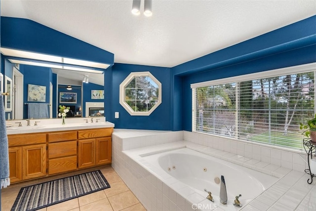 bathroom featuring tile patterned floors, a sink, double vanity, lofted ceiling, and a whirlpool tub