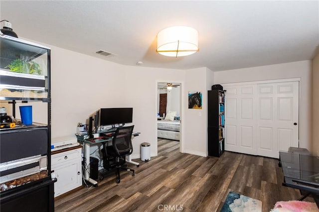 office featuring dark wood-style floors, visible vents, ceiling fan, and baseboards