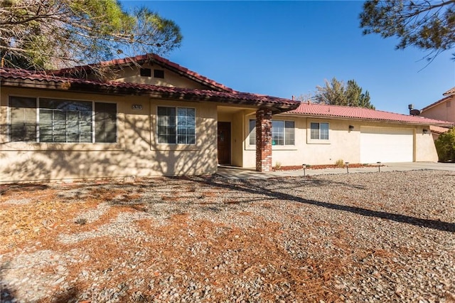 view of front of home with stucco siding, driveway, an attached garage, and a tiled roof