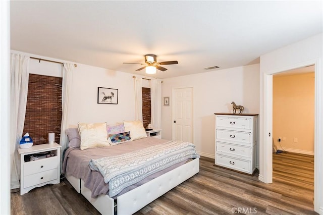 bedroom with ceiling fan, visible vents, baseboards, and dark wood-style floors