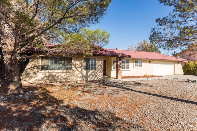 single story home featuring stucco siding, an attached garage, and concrete driveway