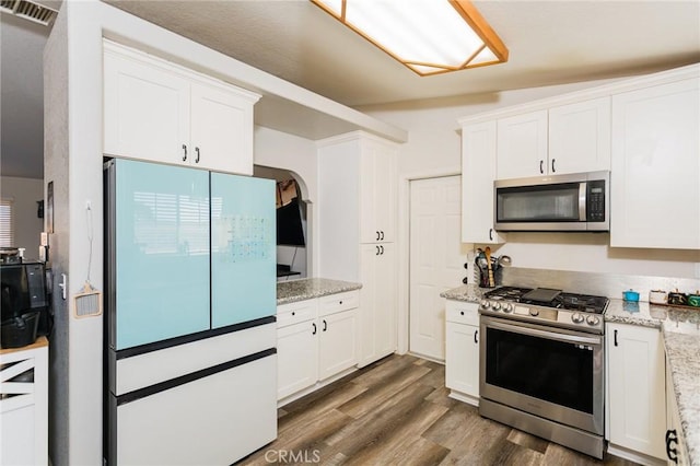 kitchen with visible vents, dark wood-type flooring, appliances with stainless steel finishes, and white cabinetry