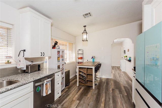 kitchen featuring visible vents, arched walkways, stainless steel dishwasher, and white cabinetry