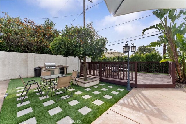 view of yard featuring a patio, outdoor dining area, and a wooden deck