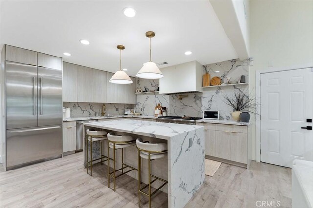 kitchen featuring modern cabinets, open shelves, a kitchen breakfast bar, a kitchen island, and appliances with stainless steel finishes