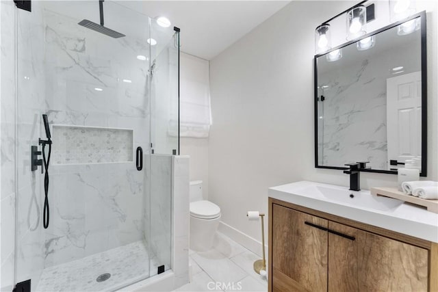 full bathroom featuring toilet, marble finish floor, a marble finish shower, baseboards, and vanity