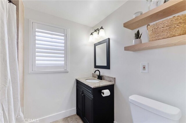 bathroom featuring vanity, a shower with curtain, baseboards, tile patterned flooring, and toilet