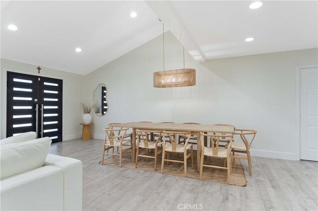 dining room featuring lofted ceiling, light wood-style flooring, recessed lighting, and baseboards