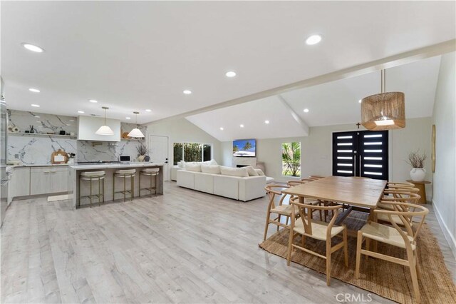 dining room with lofted ceiling, french doors, recessed lighting, and light wood finished floors