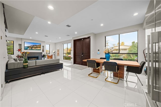 interior space featuring visible vents, recessed lighting, and a warm lit fireplace