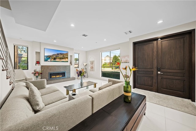 living area featuring recessed lighting, visible vents, and a glass covered fireplace