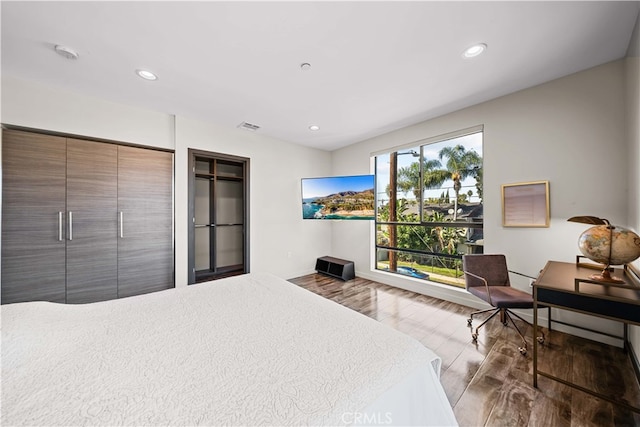 bedroom with recessed lighting, wood finished floors, and visible vents