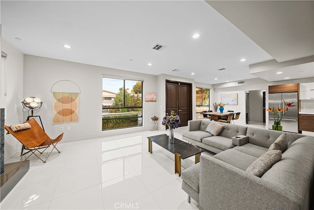 living area with recessed lighting, visible vents, and light tile patterned flooring