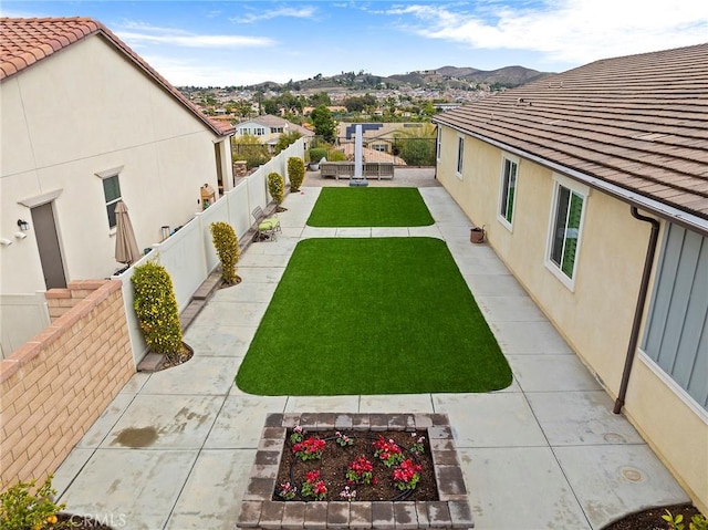view of yard featuring a patio, a fenced backyard, and a residential view