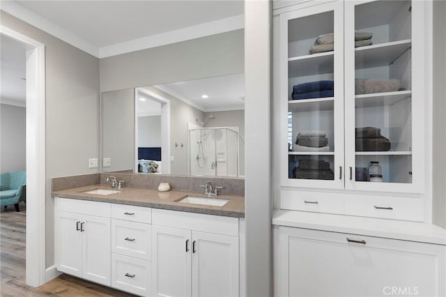 bathroom featuring ornamental molding, a stall shower, ensuite bathroom, and a sink