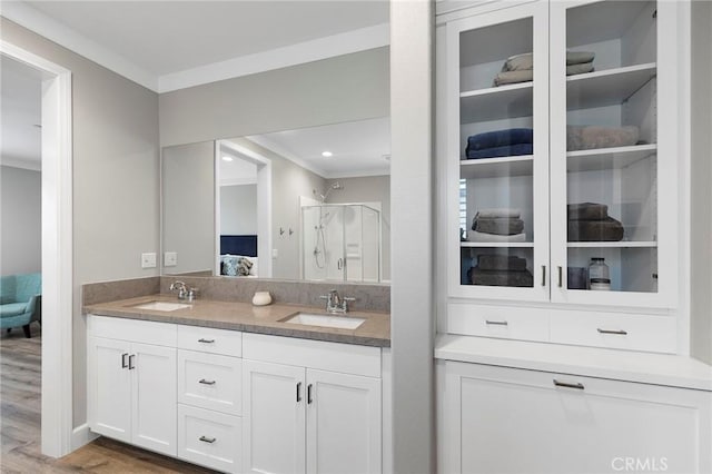 bathroom with a sink, a shower stall, ensuite bathroom, and crown molding