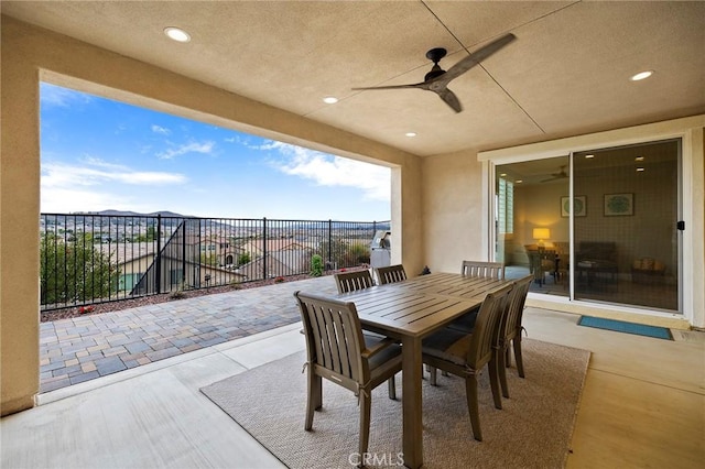 view of patio / terrace with ceiling fan, outdoor dining space, and fence