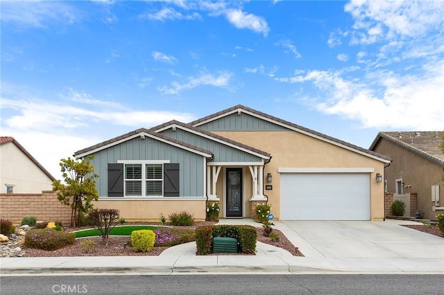 view of front of house with stucco siding, driveway, an attached garage, and fence