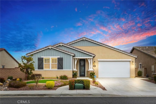 view of front of home featuring a garage, stucco siding, driveway, and fence