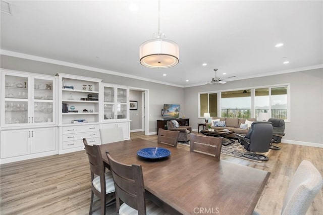 dining space with ceiling fan, crown molding, and light wood-style floors