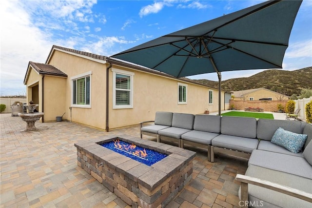 view of patio with outdoor lounge area, fence, and a mountain view