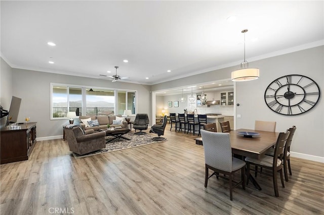 dining room featuring crown molding, recessed lighting, baseboards, and light wood finished floors