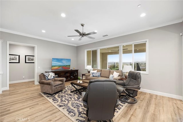 living area with baseboards, wood finished floors, ceiling fan, and crown molding