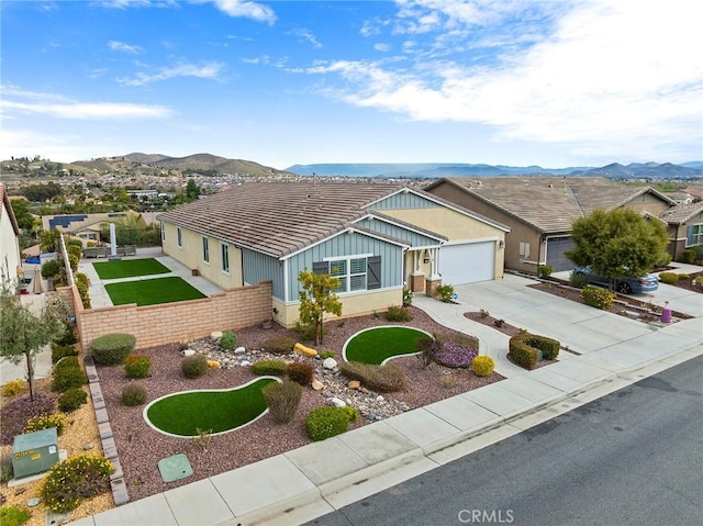 ranch-style house featuring a tiled roof, a mountain view, driveway, and fence