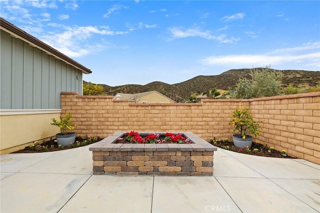 view of patio featuring a mountain view and fence