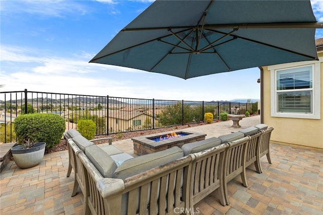 view of patio featuring an outdoor fire pit and fence