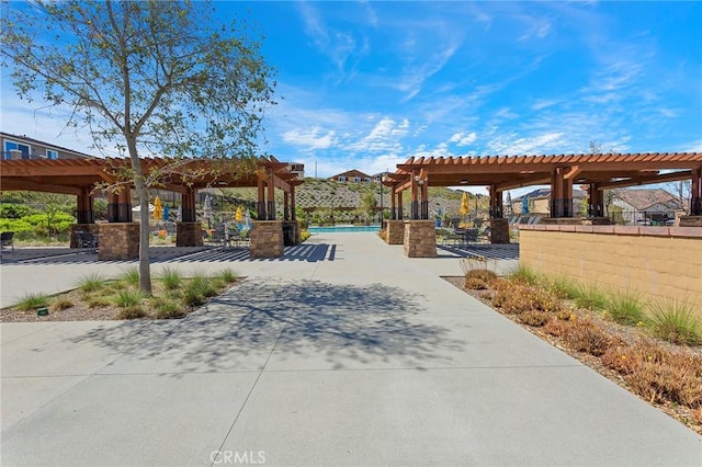 view of property's community with a patio area, a swimming pool, and a pergola