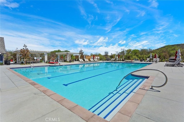 community pool with a patio area and a pergola